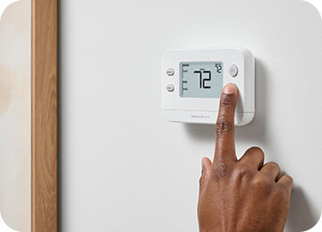 Hand turning down thermostat