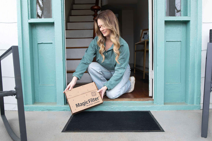 A woman receives a new air filter delivered to her home.
